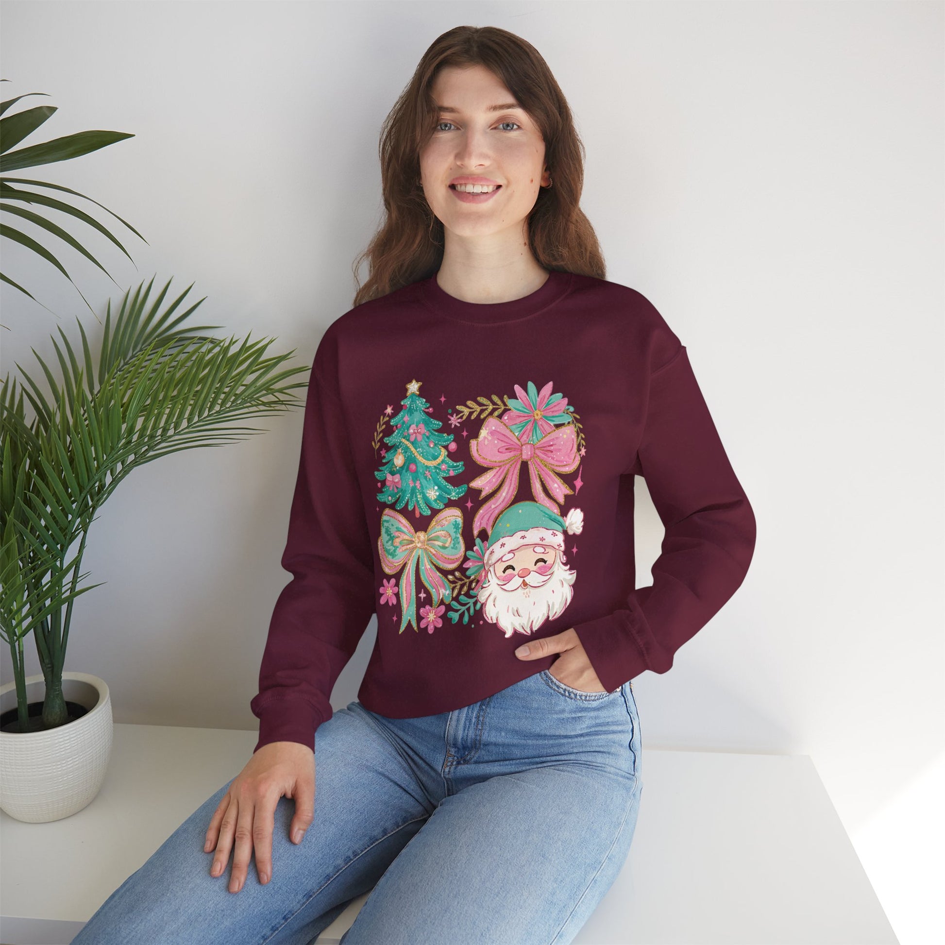 Model wearing maroon crewneck featuring pastel floral Santa and pink bow Christmas tree design.